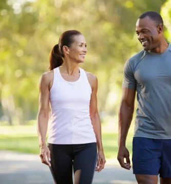 "Pareja caminando al aire libre para mejorar la salud después de los 50"